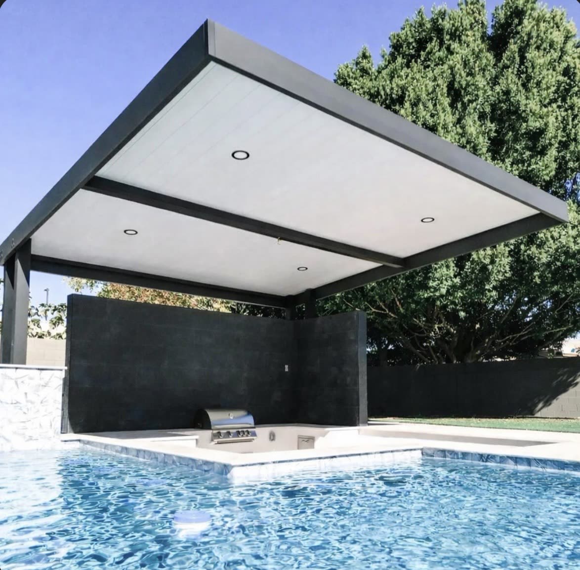 Modern aluminum shade structure beside a custom shotcrete pool in Greenwood Village